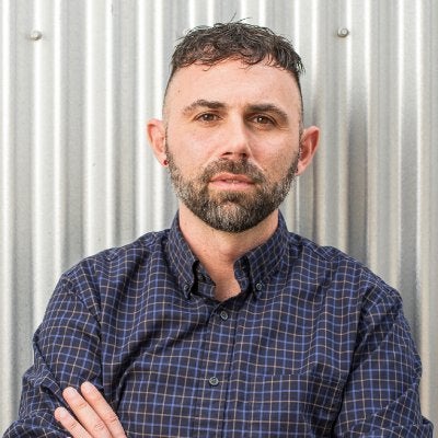 Phil Hammack, man with short hair, closely shaved sides of head, beard, arms crossed