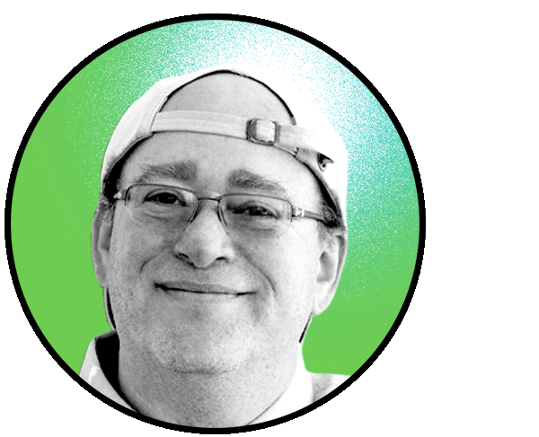 Brian Shoichet smiles at the camera wearing glasses and a backwards cap. The image frame is circular and cropped closely around Brian's face, which is in black and white, against a green background.