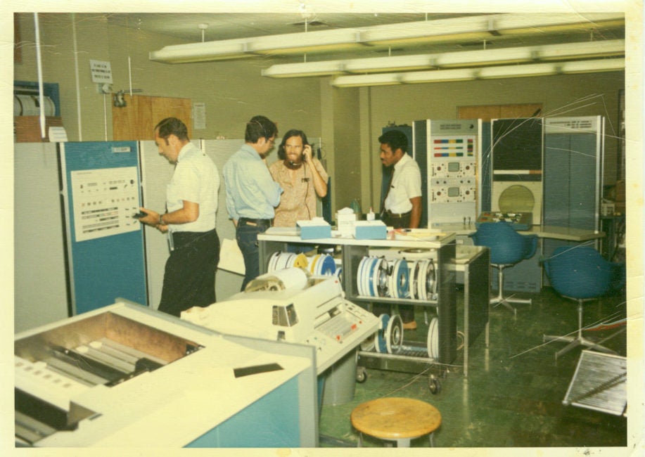 Vintage photo of four men hanging out in a 1960's-era computer lab