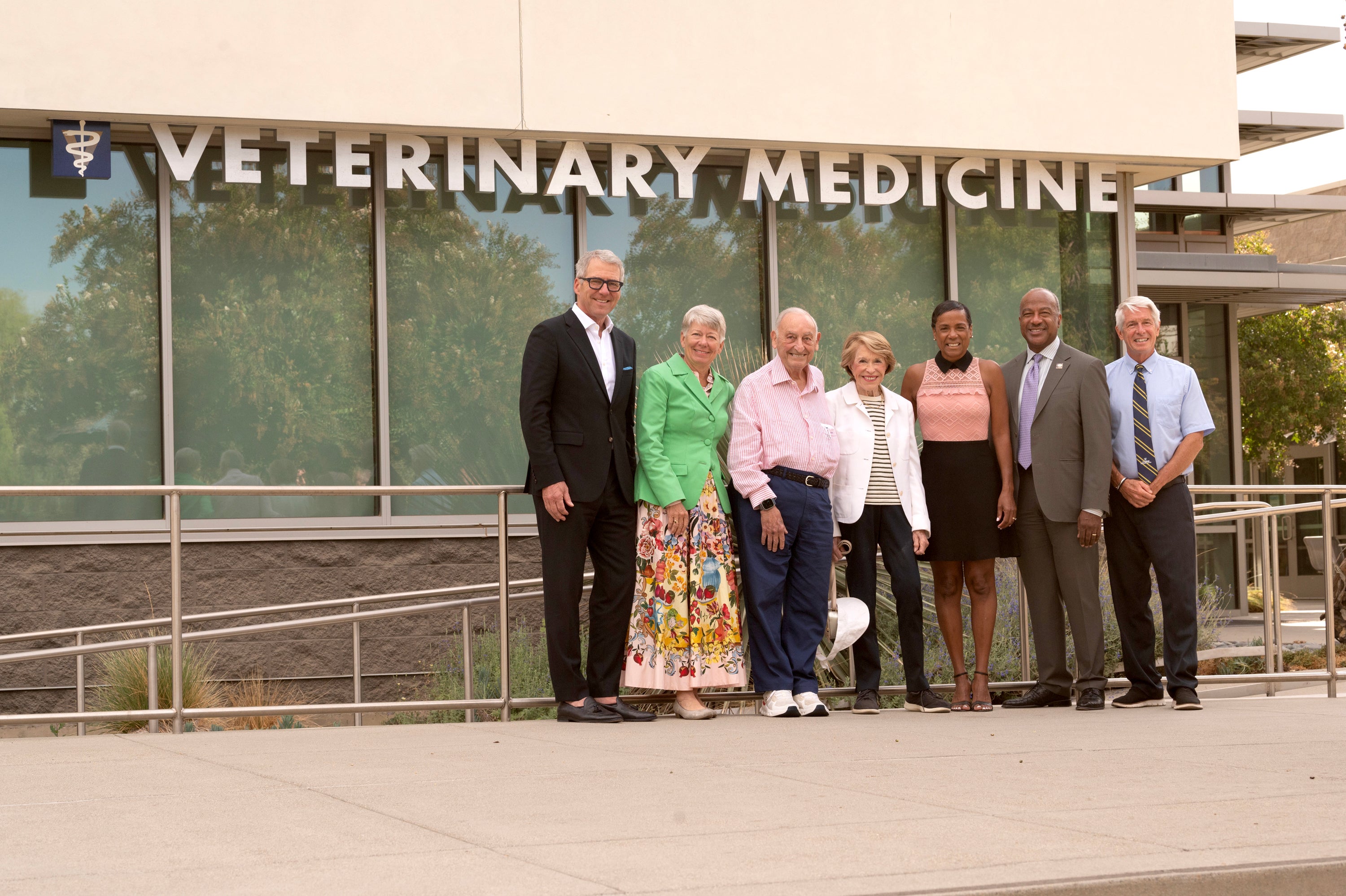 Seven people stand outside the Vet Med building on the UC Davis campus