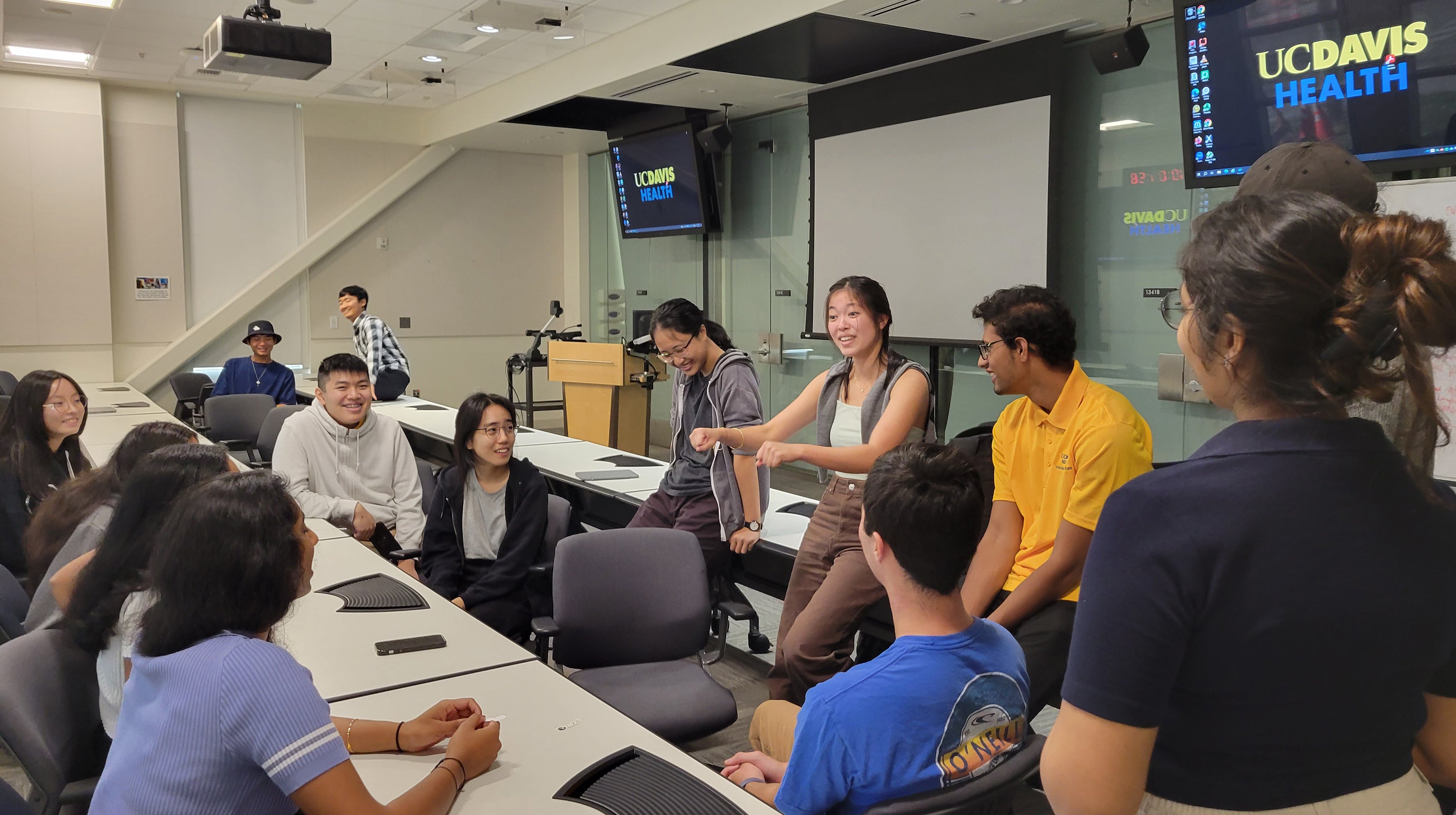 People gathered in a classroom having a lively conversation