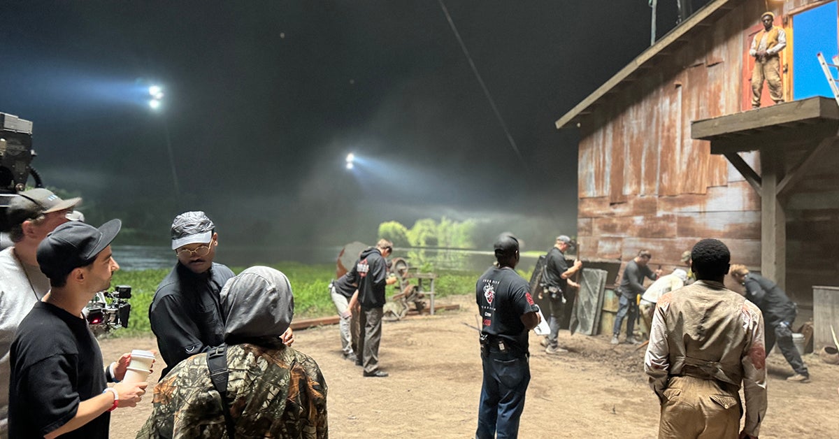 A number of people on the set of a lumbermill at night