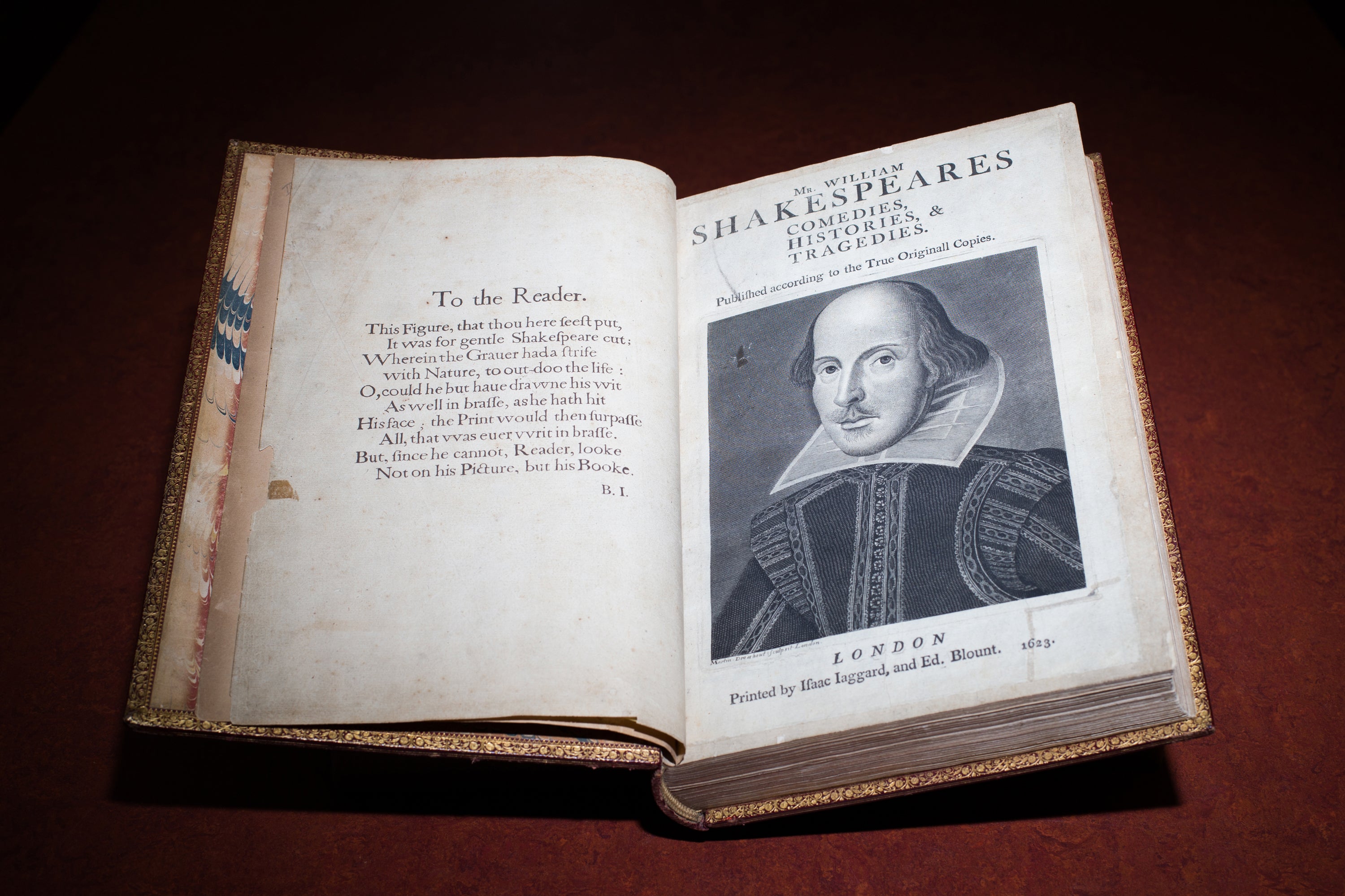 The book "Shakespeare's First Folio" open to a page with an illustrated portrait of the author
