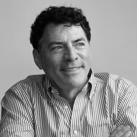 A black-and-white headshot of a man in a dress shirt