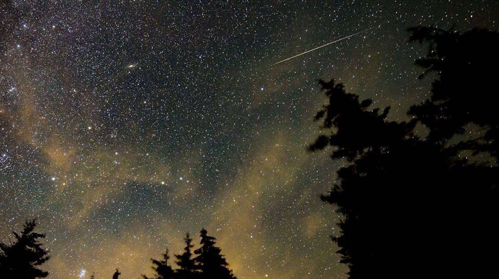 A view of a night sky with a meteor streaking across