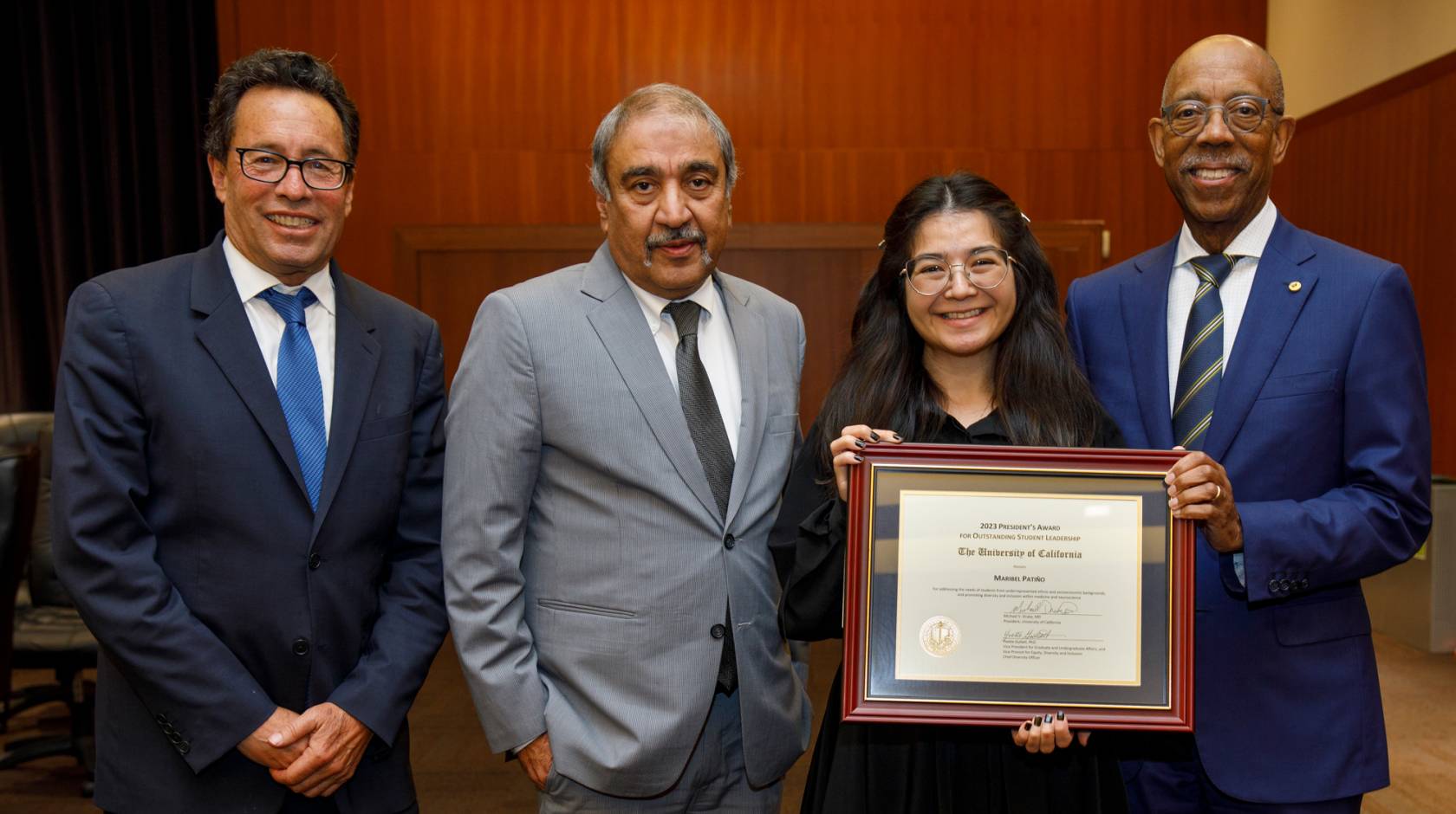 Chair Richard Leib, Chancellor Khosla, a young Latina woman Maribel Patiño, and President Drake 