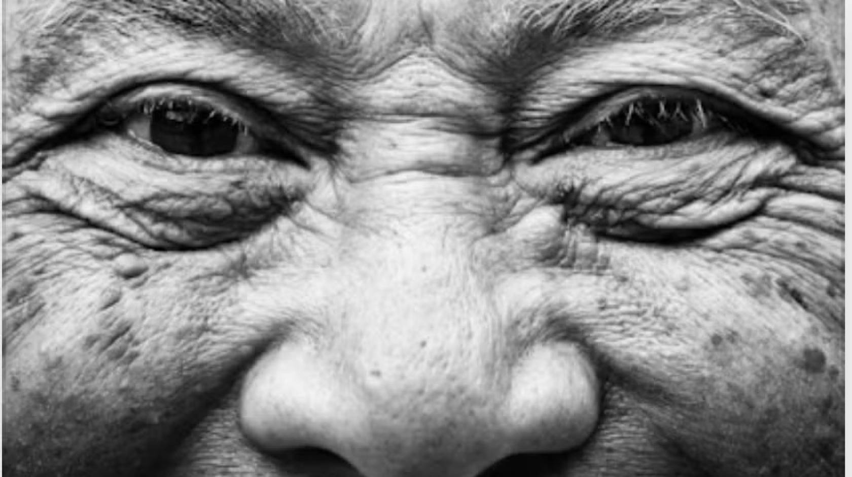 A close-up of an older person's smiling face and wrinkles