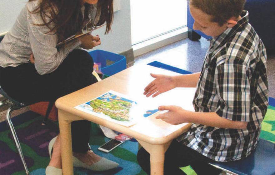 A UC Riverside SEARCH Center staffer works with an autistic child