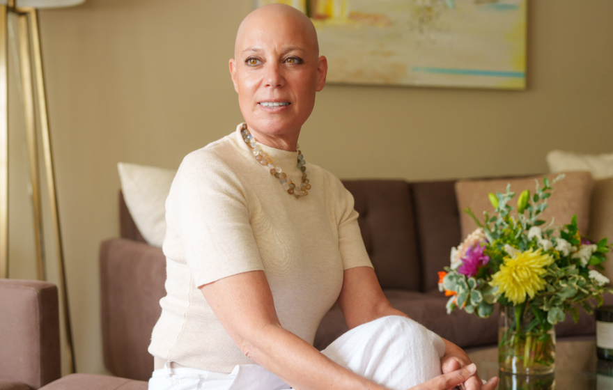 Well-dressed woman without hair on her head from chemotherapy looks into the distance