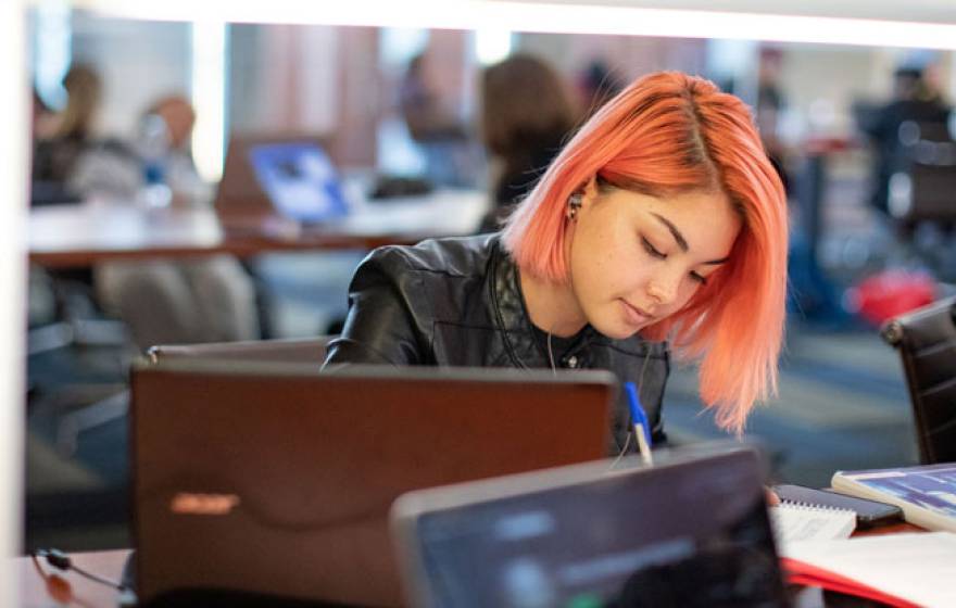 Young woman with orange hair studying