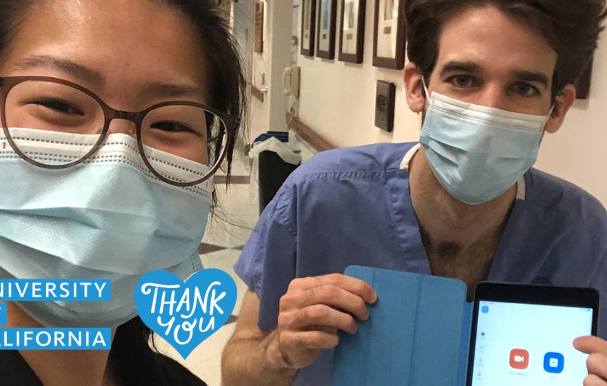 Two medical residents display tablet program