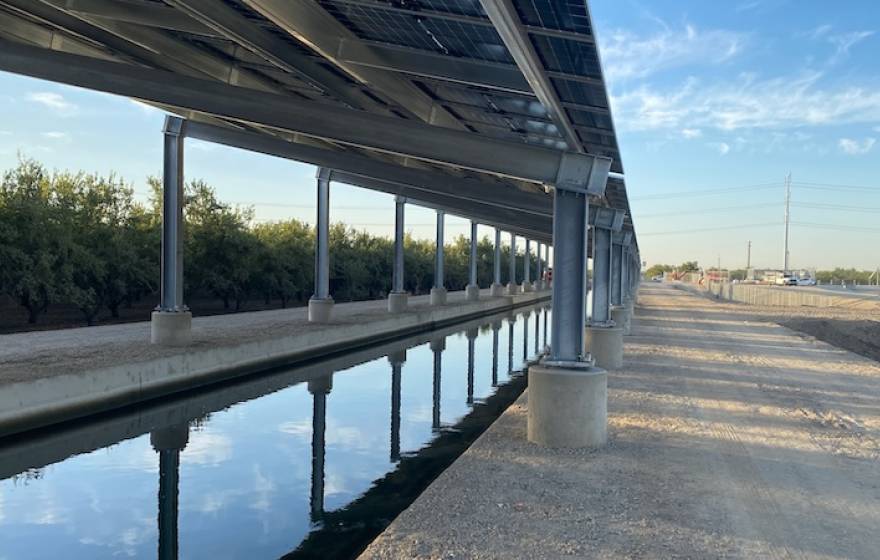 Solar panels over a canal near a highway
