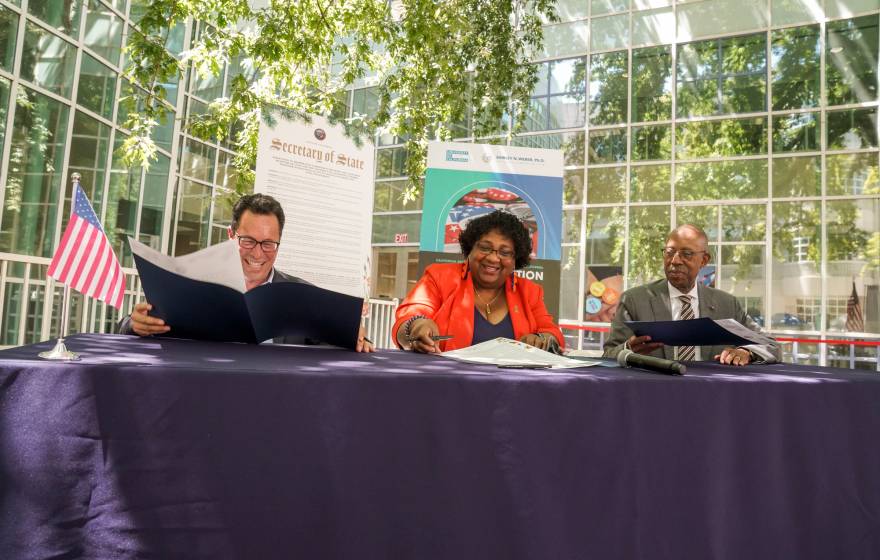 UC Board of Regents Vice Chair Leib, California Secretary of State Weber and UC President Drake sign voting resolution at UC Davis.