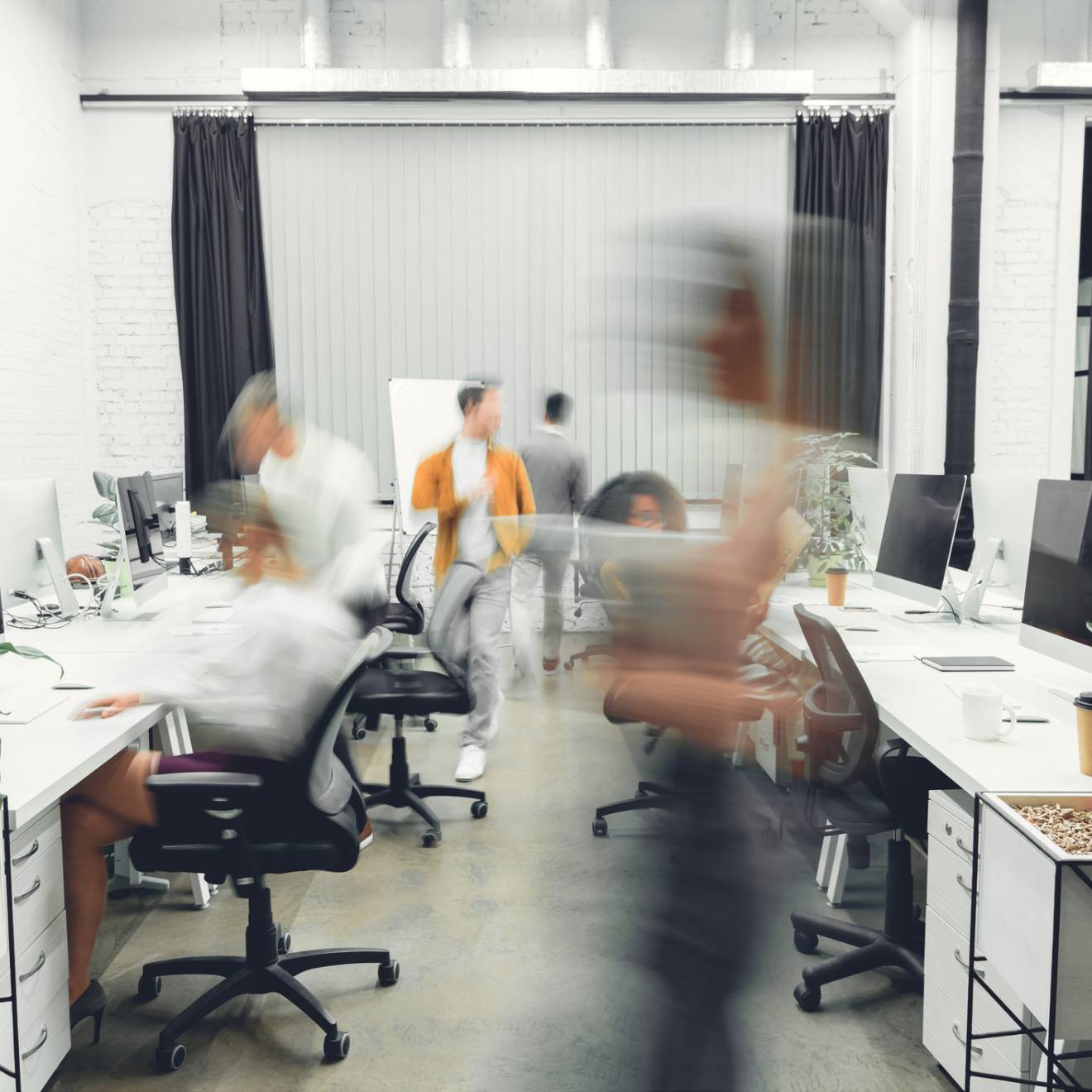 contemporary open space office interior with blurred coworkers in motion