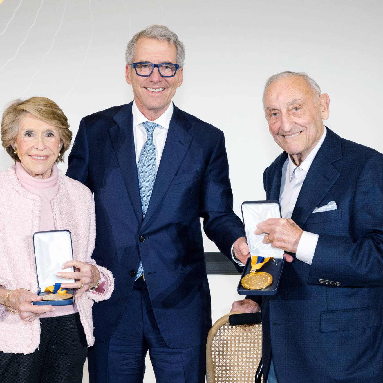 Joan Weill, left, stands next to President Milliken, who is next to Sanford I. Weill, both Weills holding their gold medals 