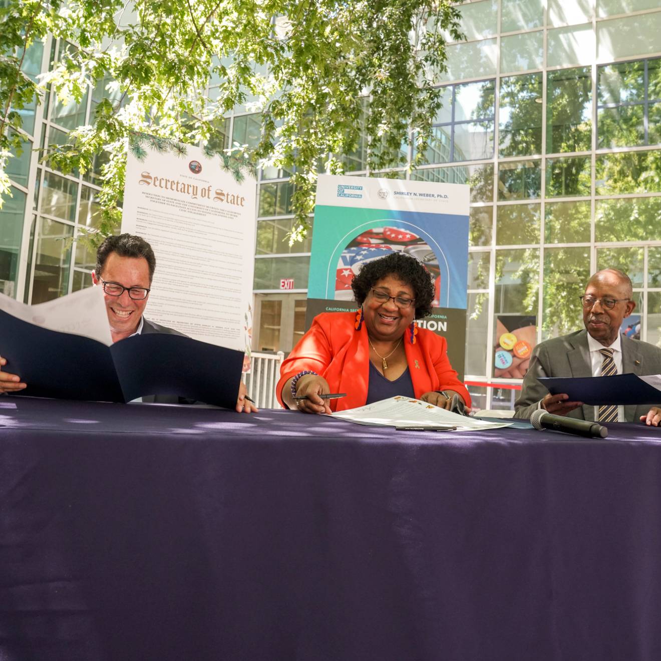 UC Board of Regents Vice Chair Leib, California Secretary of State Weber and UC President Drake sign voting resolution at UC Davis.